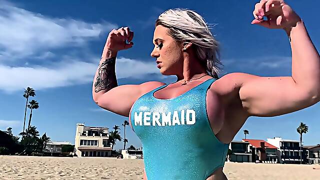 Muscle blonde milf flaunts amazing curves on the beach